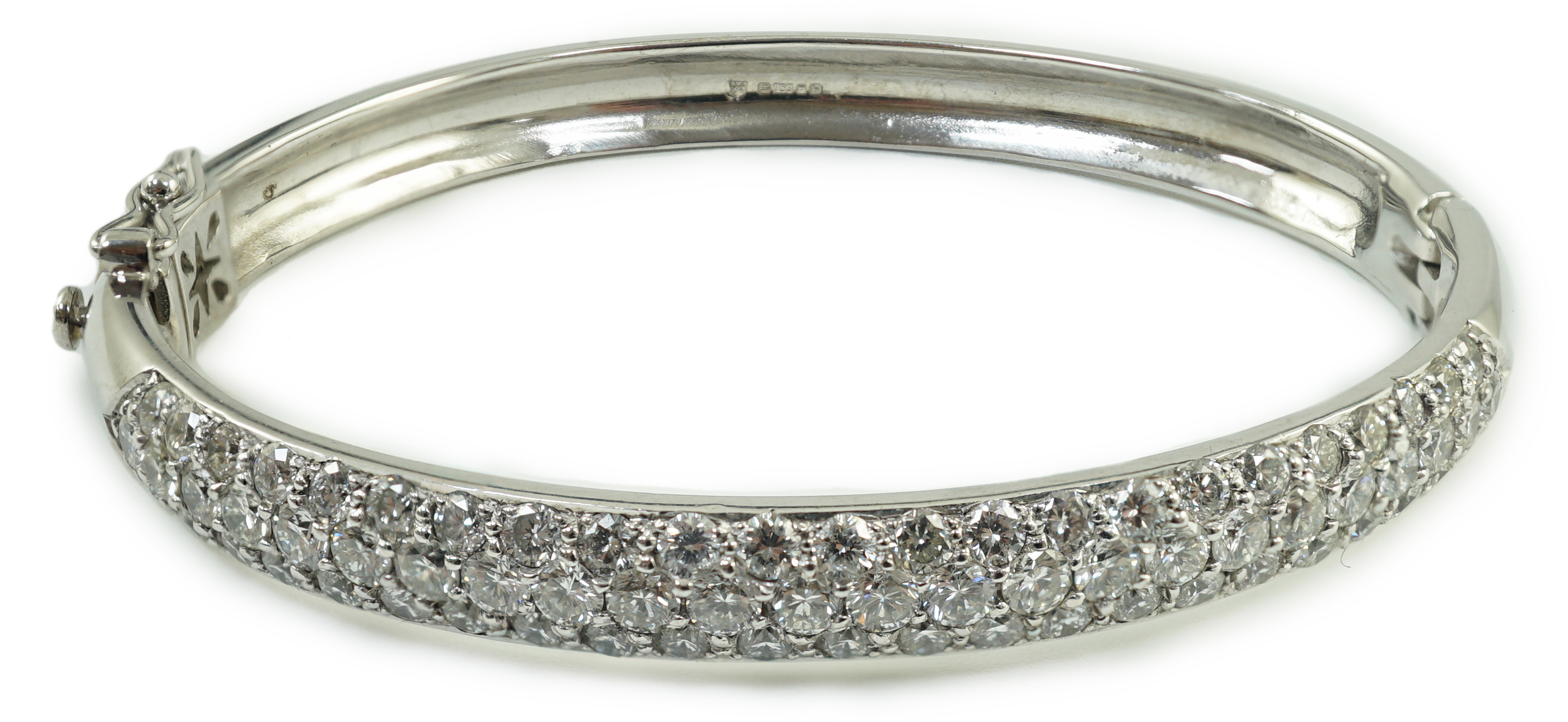 A modern 18ct white gold and pave set diamond hinged bangle